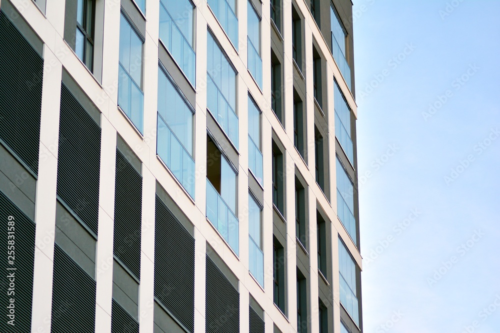 Multistory new modern apartment building. Stylish living block of flats. Modern, new executive apartments and with deep blue summer sky Multistory new modern apartment building. Stylish living block of flats. Modern, new executive apartments and with deep blue summer sky