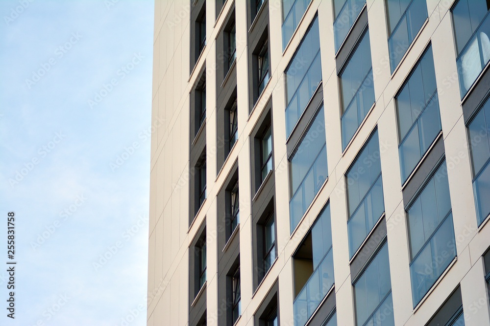 Multistory new modern apartment building. Stylish living block of flats. Modern, new executive apartments and with deep blue summer sky Multistory new modern apartment building. Stylish living block of flats. Modern, new executive apartments and with deep blue summer sky