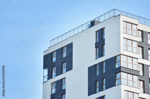 Multistory new modern apartment building. Stylish living block of flats. Modern, new executive apartments and with deep blue summer sky