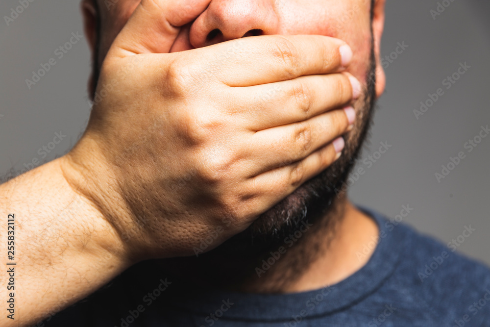 Fototapeta premium Close-up of a man hand covering his mouth - hand on mouth