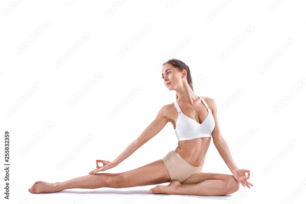 Beautiful woman with perfect body practicing Yoga poses full length in studio isolated on white background.