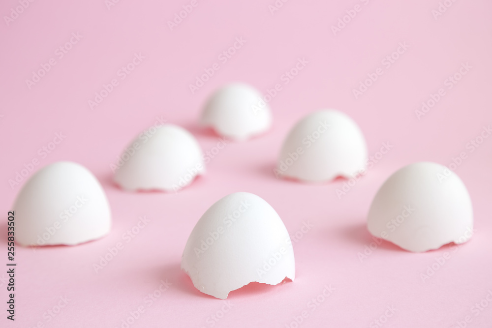 Cracked eggshells abstract isolated on rose.