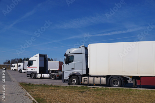 Rest area for drivers. A row of trucks in the parking lot.