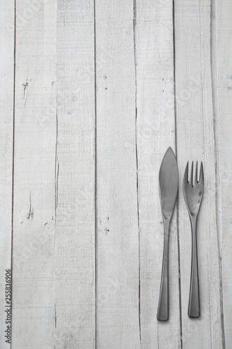 Cutlery on white wooden background ready to eat. Empty space