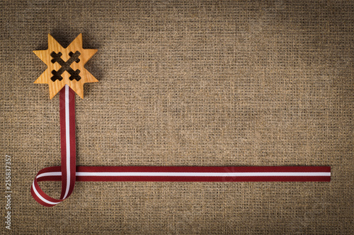 National composition of latvian flag ribbon and wooden symbol Auseklis photo
