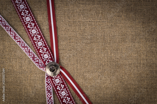 National ribbons fastened with a latvian brooch Sakta photo