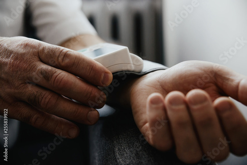 Blood pressure testing with a blood pressure meter. A blood sphygmomanometer placed on the wrist. Medical and pharmaceutical concept, problems and hypertension. Heart problems, heart attack. photo