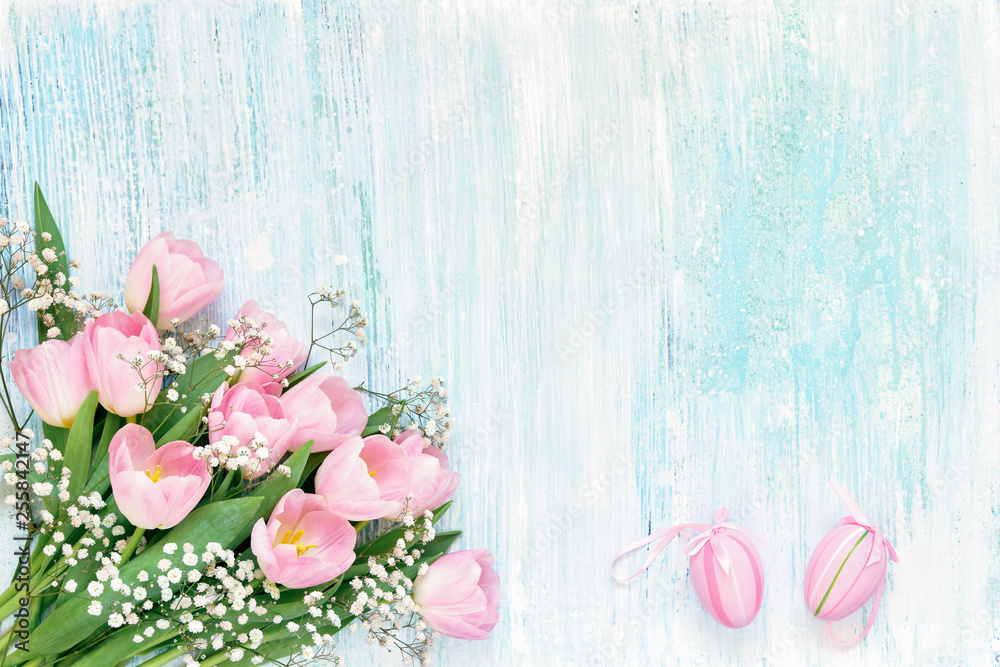 Easter background. Pink tulips and Easter eggs on blue background. Copy space, top view. Easter background. Pink tulips and Easter eggs on blue background. Copy space, top view.