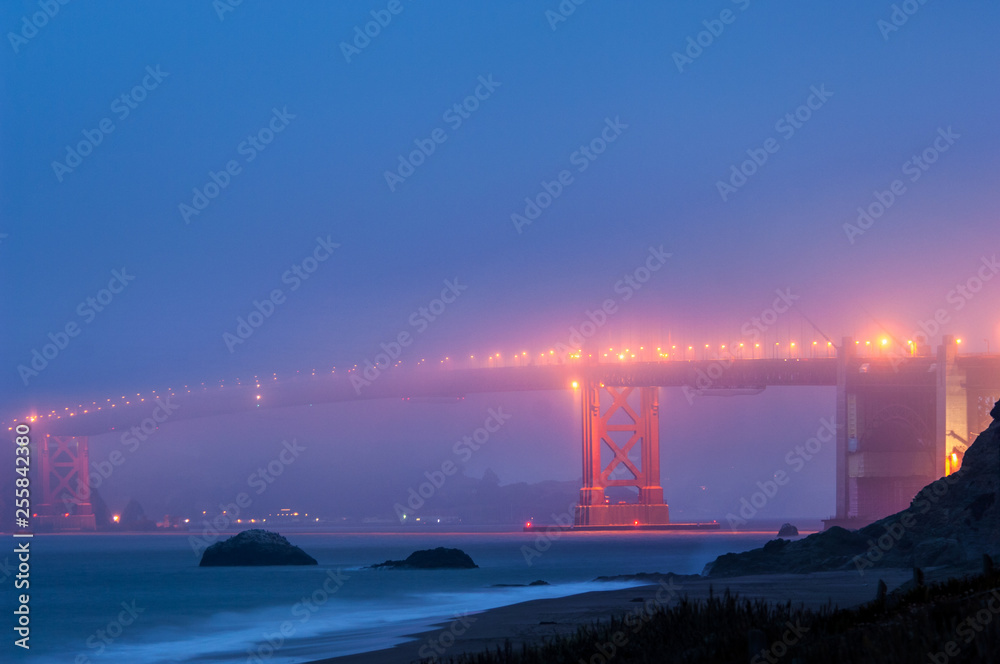 Golden Gate bridge at foggy night viewed from Baker Beach, San Francisco, California