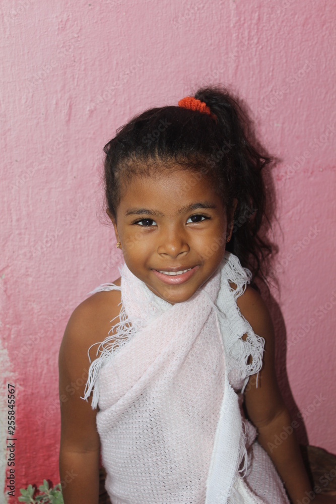 Portrait of happy little girl. On a pink wall. African-American mixed race child. Portrait of happy little girl. On a pink wall. African-American mixed race child.