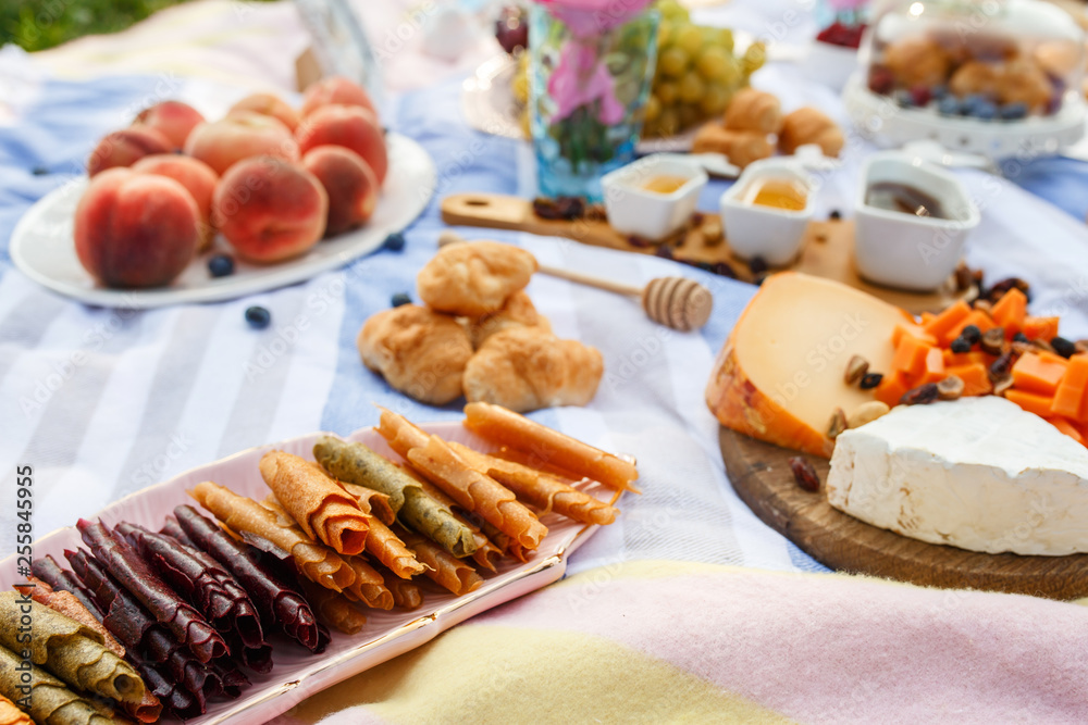 Summer picnic blanket with tasty food and snacks on it. Summer weekends