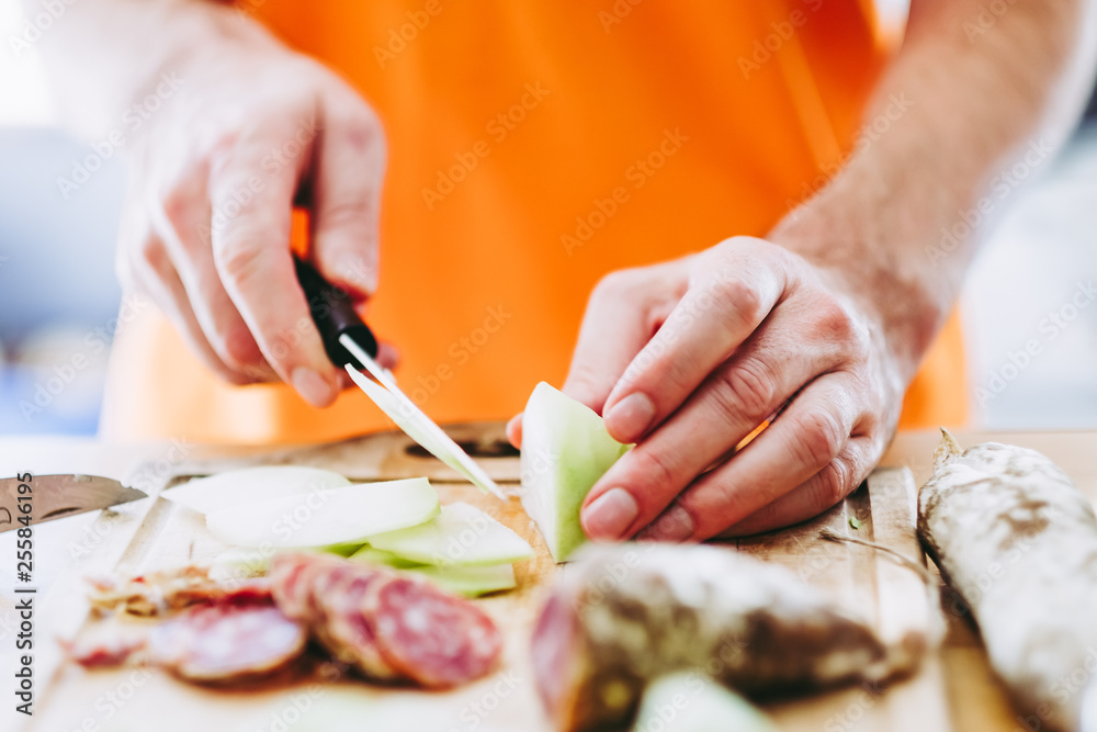 Mains d'un homme en train de couper des légumes Mains d'un homme en train de couper des légumes
