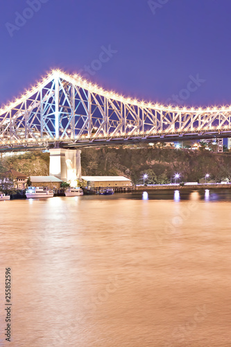 Yellow river and a bridge with lights at night
