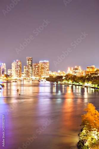Night city photo with illuminating bright lights beside a river