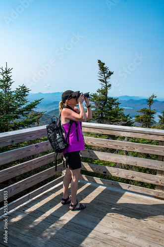 Woman with pink top taking photos of the landscape
