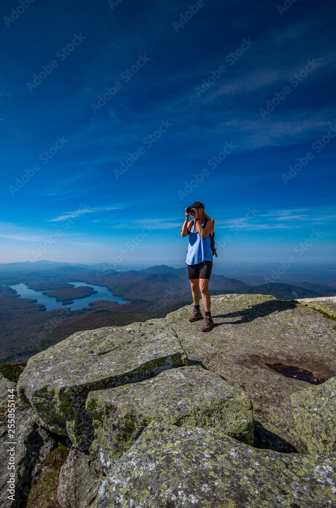 Female hiker taking photos from the summit of Whiteface Mountain