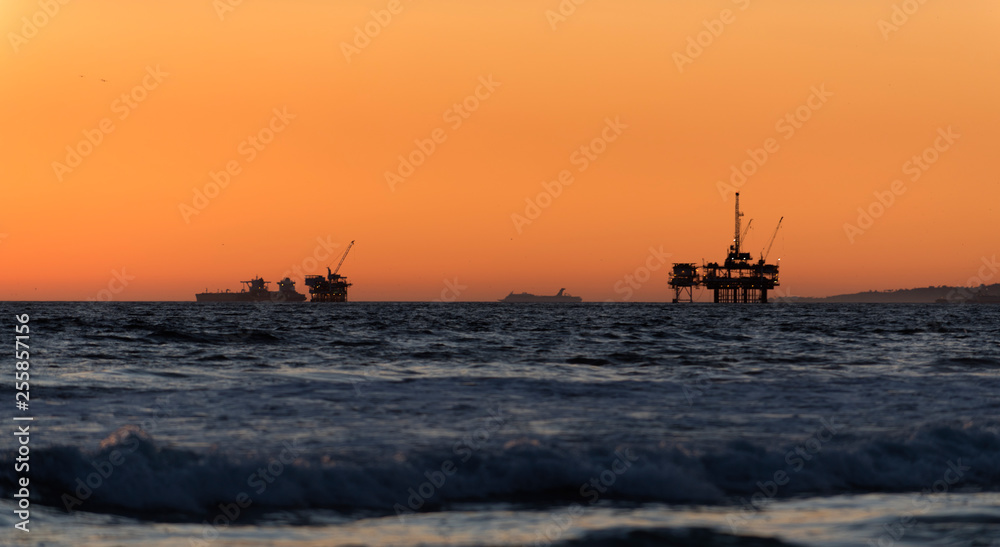 Offshore oil drilling rigs at sunset