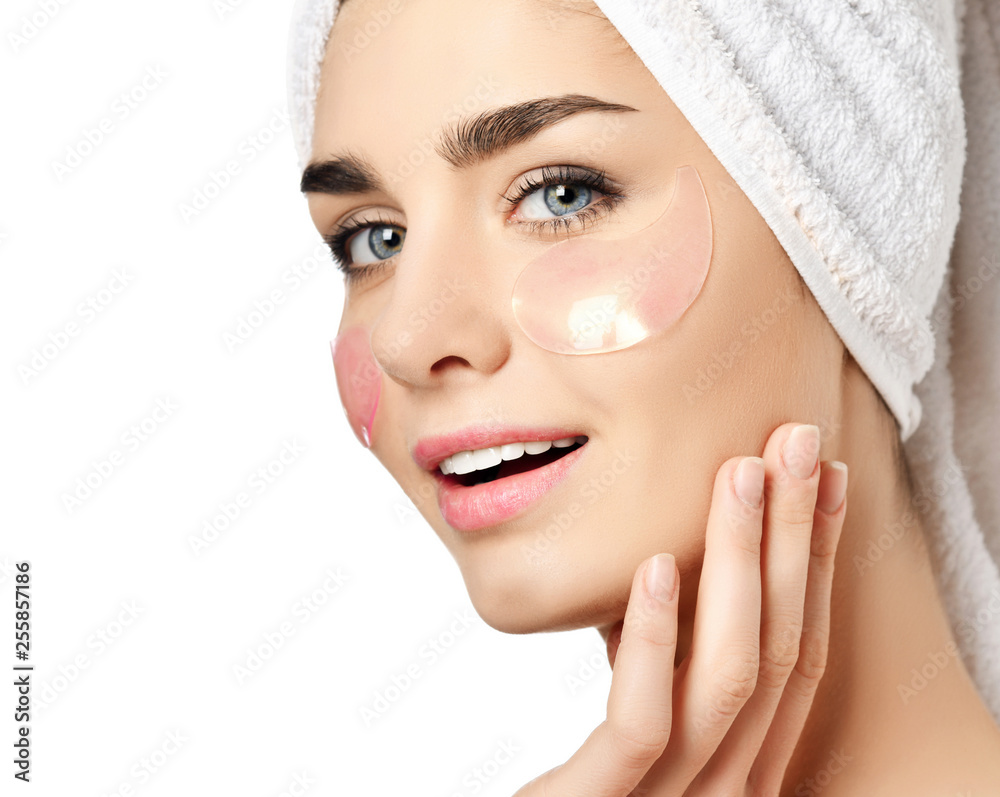 Beautiful woman just after shower with cosmetic patches on skin under eyes touches her cheek and delights the condition of her skin Beautiful woman just after shower with cosmetic patches on skin under eyes touches her cheek and delights the condition of her skin