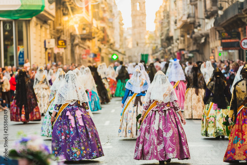 Several of the thousands of women Falleras who parade down the street of La Paz with their typical Valencian Spanish dresses during the offering of Fallas to the Virgin, seen from behind. © Joaquin Corbalan