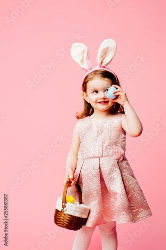 Portrait of a little toddler girl with bunny ears and easter egg