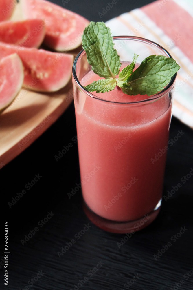 Glass of guava smoothie and slice of its fruit Glass of guava smoothie and slice of its fruit