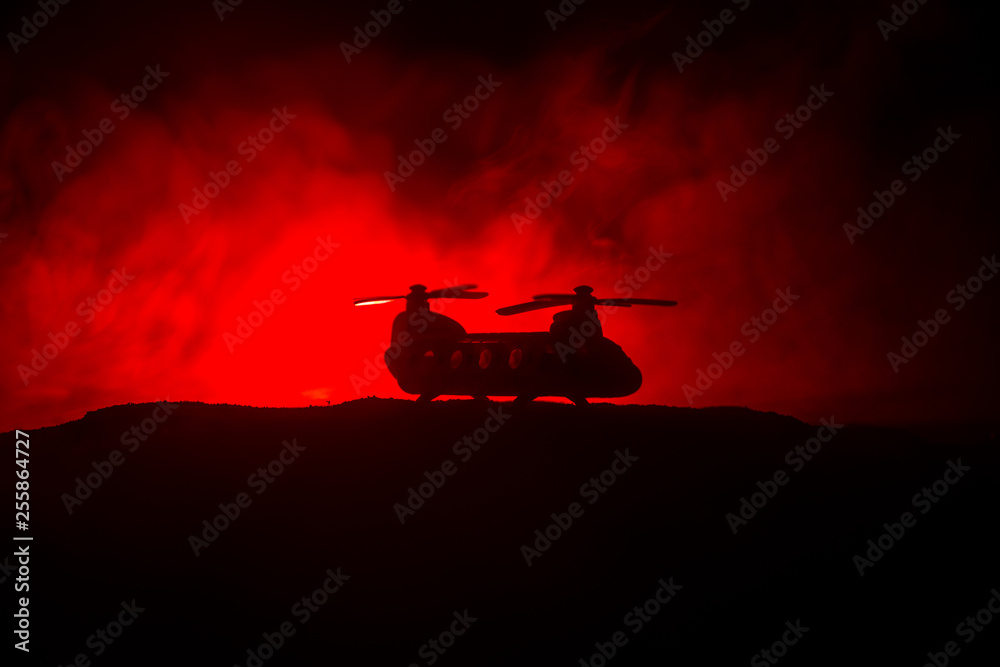 Silhouette of military helicopter ready to fly from conflict zone. Decorated night footage with helicopter starting in desert with foggy toned backlit. Selective focus. Silhouette of military helicopter ready to fly from conflict zone. Decorated night footage with helicopter starting in desert with foggy toned backlit. Selective focus.