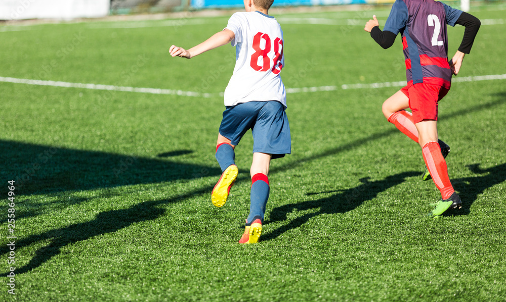 Football training soccer for kids. Boy runs kicks dribbles soccer balls. Young footballers dribble and kick football ball in game. Training, active lifestyle, sport, children activity concept Football training soccer for kids. Boy runs kicks dribbles soccer balls. Young footballers dribble and kick football ball in game. Training, active lifestyle, sport, children activity concept