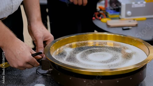 Sound vibration transforms white sand particles on steel surface at technology futuristic exhibition. Science, resonance and physics concept photo