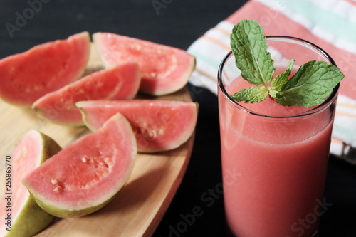 Glass of guava smoothie and slice of its fruit photo