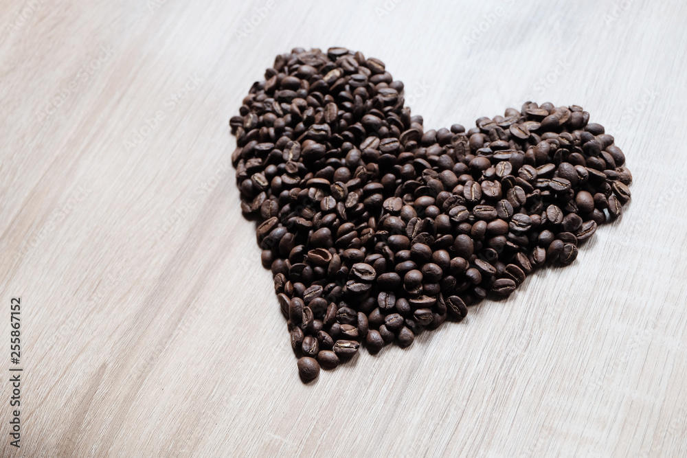 Heart shape arranged by coffee beans and wood pattern as background Heart shape arranged by coffee beans and wood pattern as background