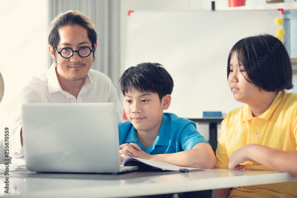 Tutor room children in class learning on laptop computer Tutor room children in class learning on laptop computer