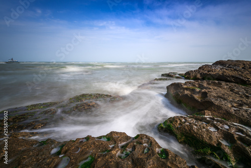 Colorful sea shore with green algae  long exposure water