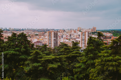 Aerial view of buildings in the city with green trees in Madrid, Spain.