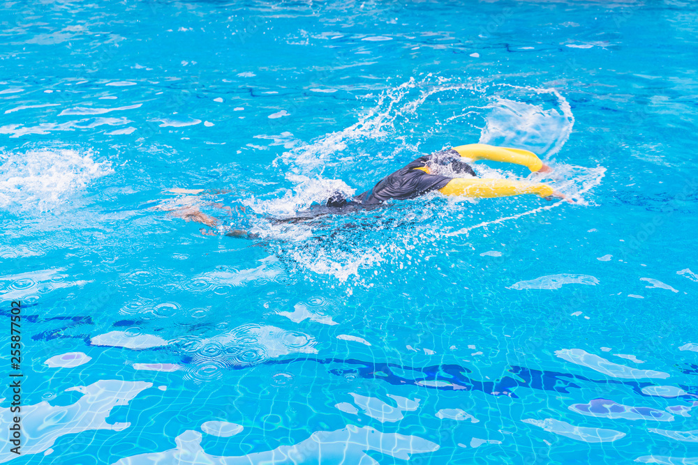 dynamic and fit swimmer in cap breathing performing the butterfly stroke. Butterfly posture.
