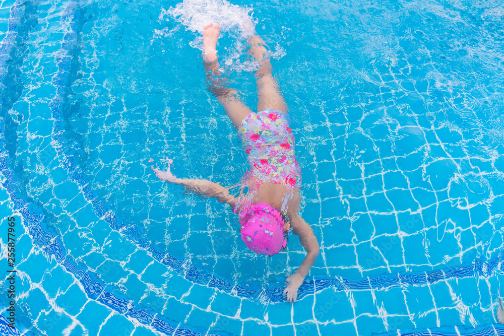 Child playing in swimming pool. Summer vacation concept. First time for swimming. swimming pool class learning to swim.