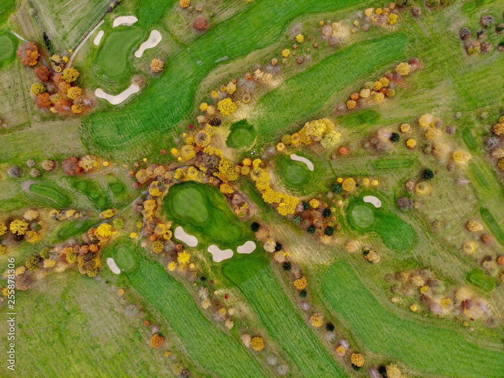 Obraz premium Aerial view of a golf course. Beautiful colorful trees and green course during autumn/winter season in the South of Belgium, Walloon Brabant.