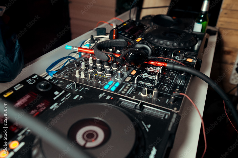 DJ console cd mp4 deejay mixing desk Ibiza house music party in nightclub  with colored disco lights. Stock Photo | Adobe Stock