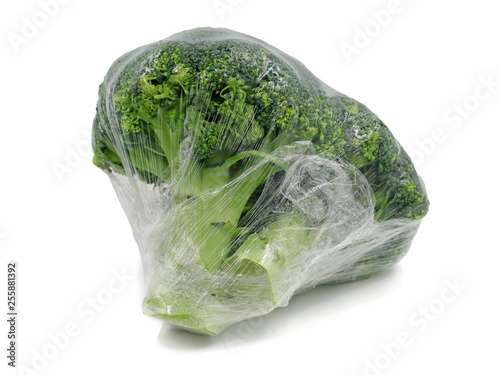 Broccoli wrapped in plastic foil isolated on white background