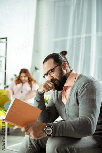 Positive delighted brunette man reading his notes