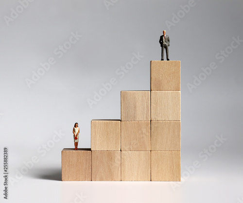 Wooden blocks and miniature people. The concept of gender discrimination in a company.