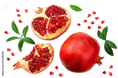 piece of pomegranate with seeds and green leaves isolated on a white background. top view