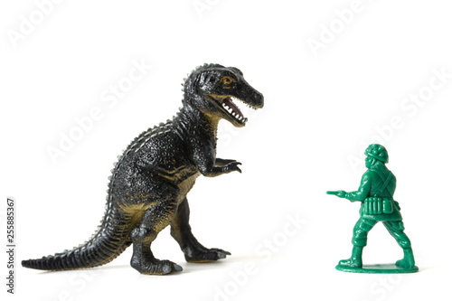 plastic dinosaur fighting with a toy soldier © Leonid