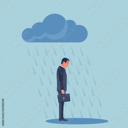 Sad businessman standing in the rain