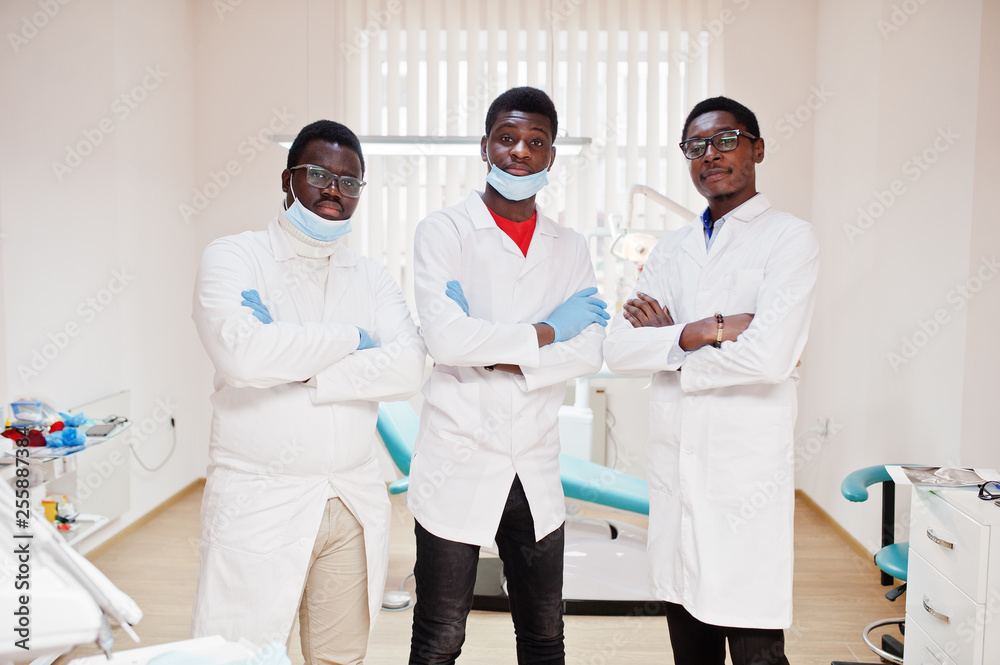 Three african american male doctor with crossed arms in dental clinic. Three african american male doctor with crossed arms in dental clinic.