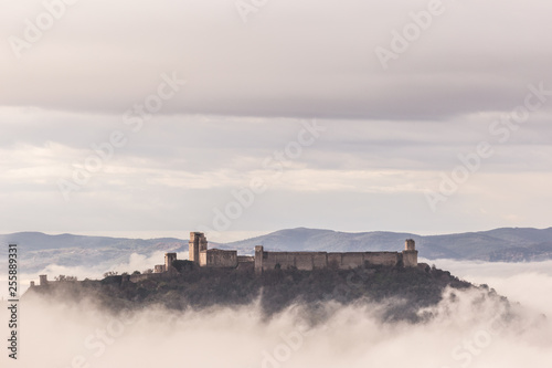 A view of Rocca Maggiore castle in Assisi (Umbria, Italy) in the middle of fog photo