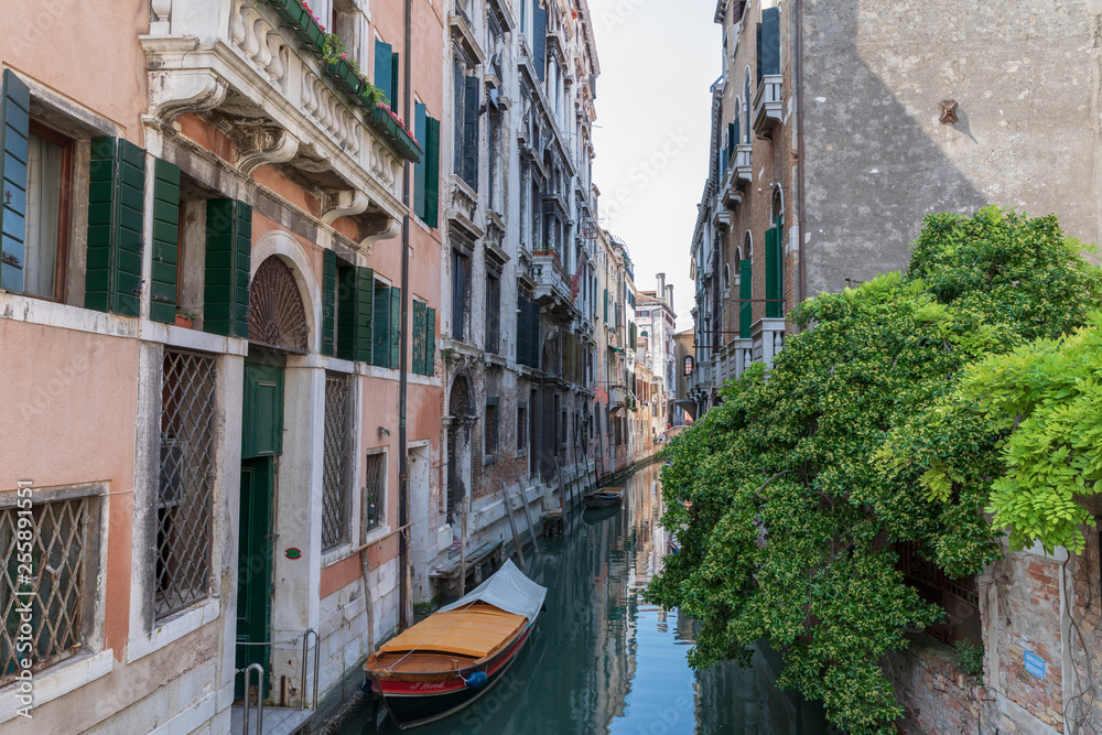 Panoramic view of Venice narrow canal with historical buildings and boat