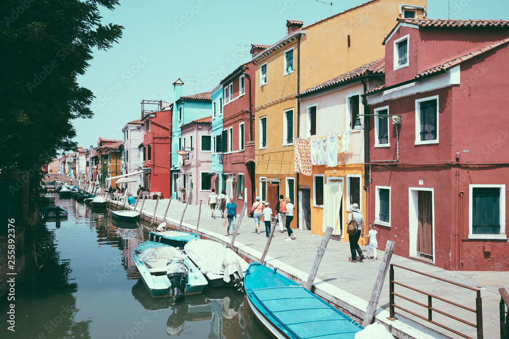 Panoramic view of coloured homes and water canal with boats in Burano