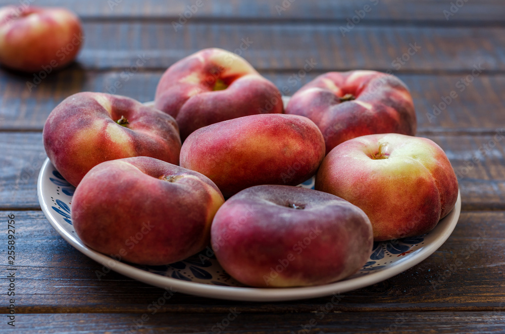 Ripe flat variety peaches in a clay dish. Ripe flat variety peaches in a clay dish.
