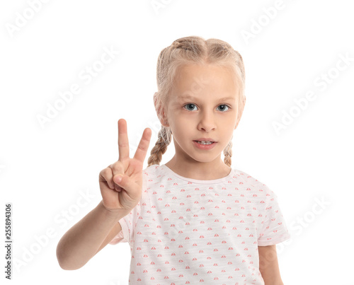 Little girl showing victory gesture on white background