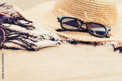 Vintage summer wicker straw beach bag, sun glasses and bag on the sand.